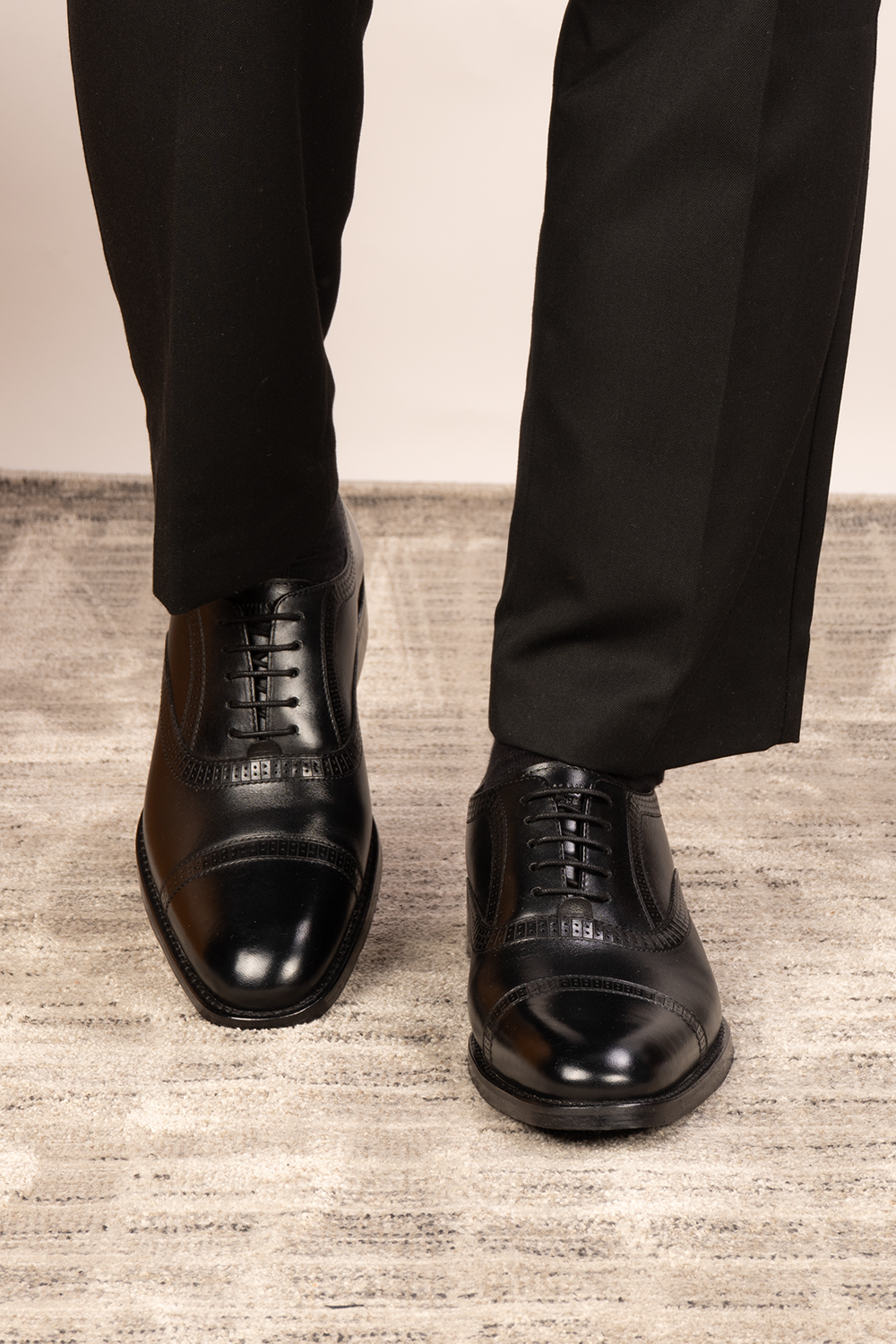 Creed black leather men's brogue shoes with a classic five-eyelet toecap design, featuring polished finish and timeless sophistication
