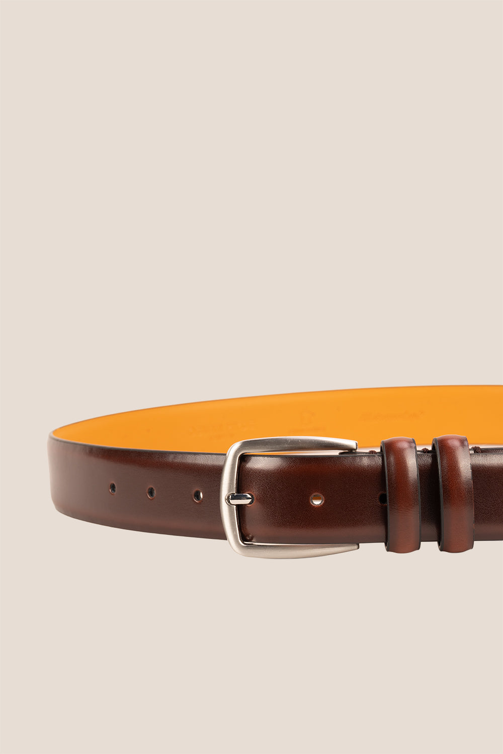 Gavin Brown leather belt with a silver buckle on a beige background