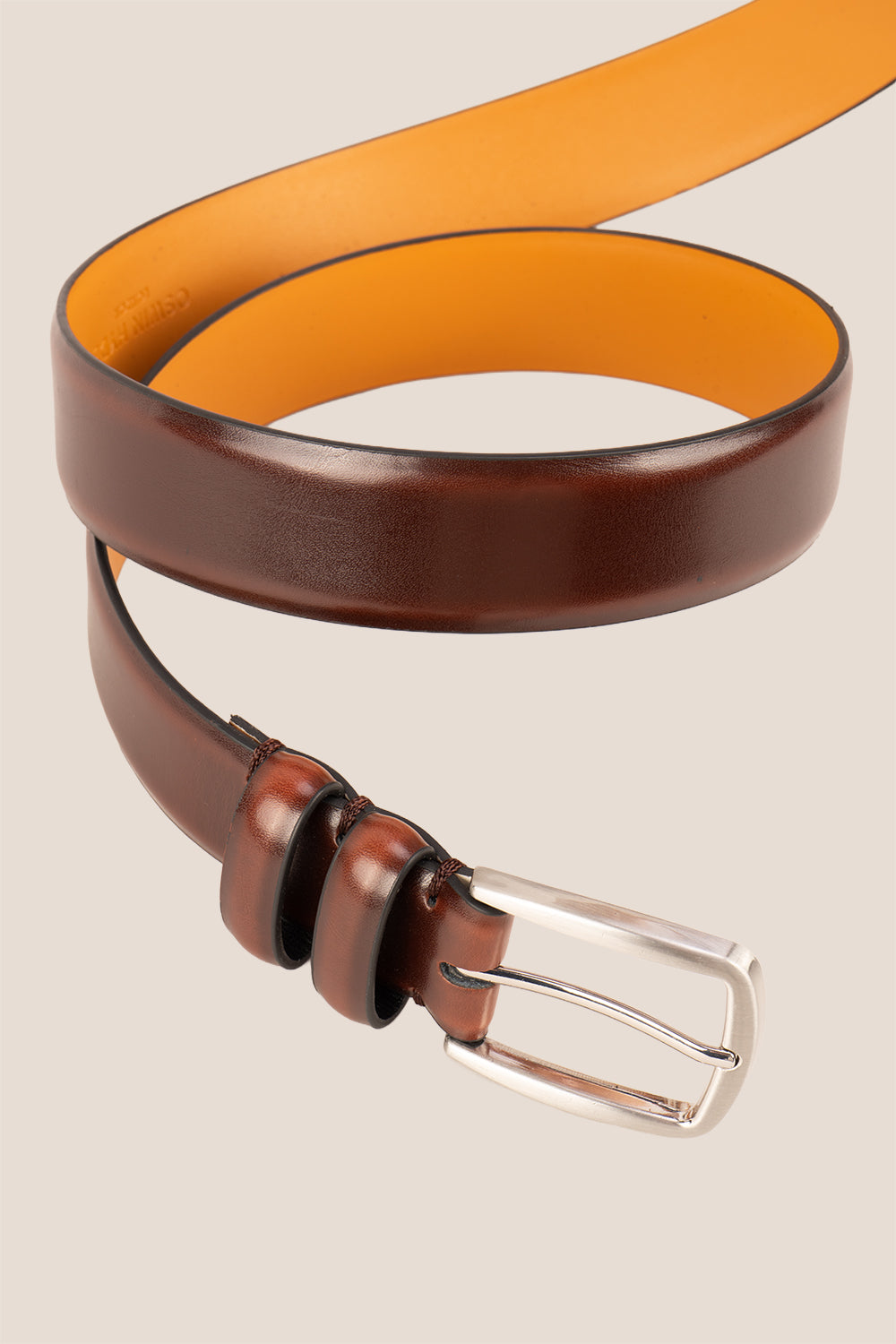 Gavin Brown leather belt with a silver buckle on a beige background