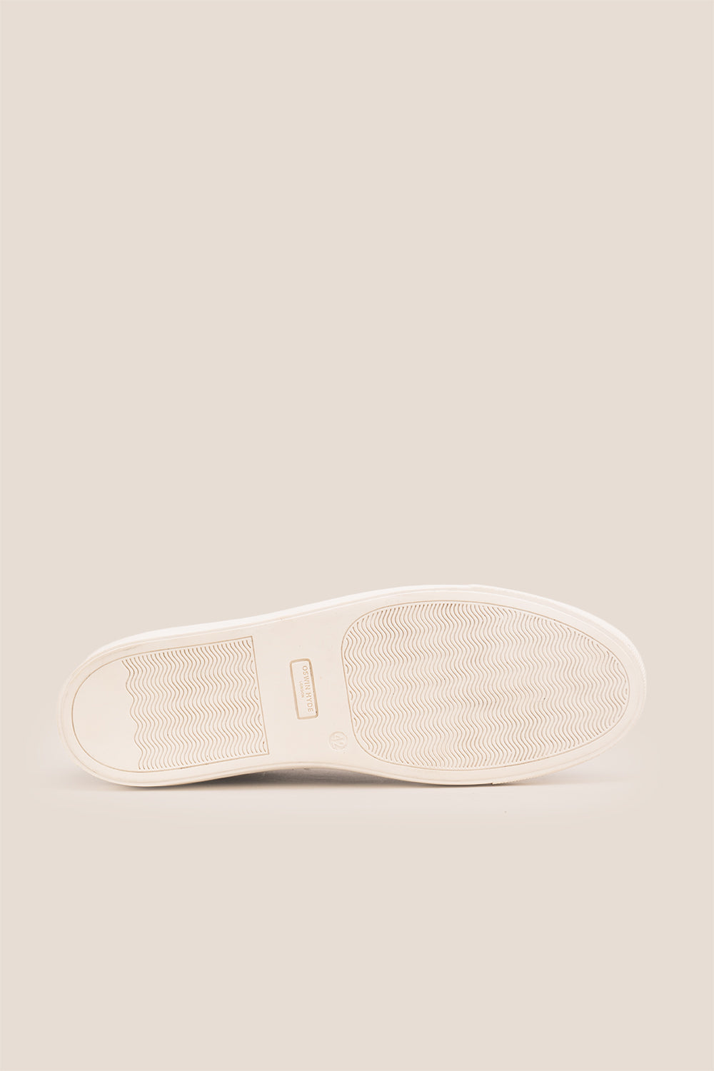 Black leather sneaker on a beige background
