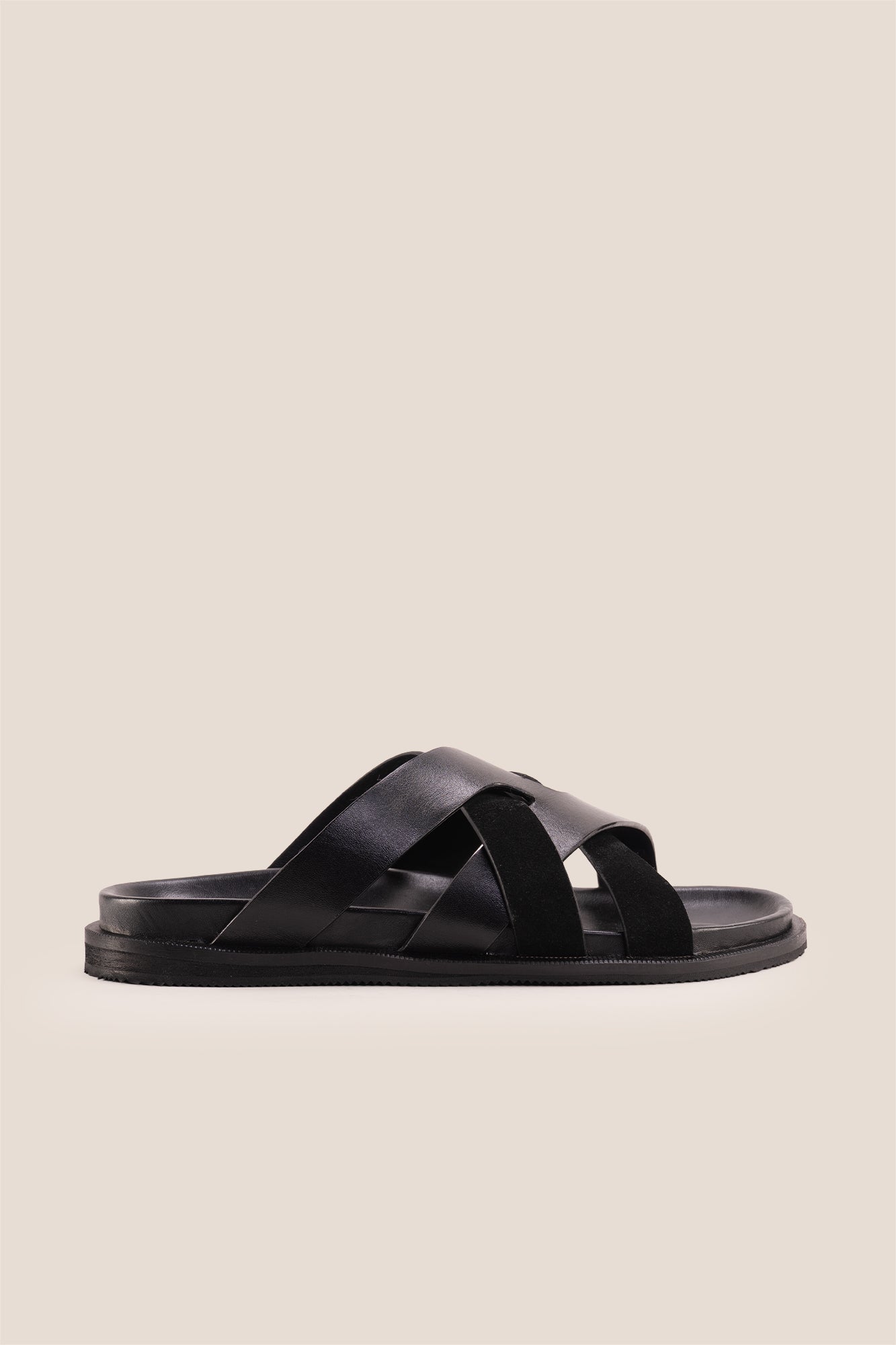 Men’s Rowan Black slide sandals featuring a minimalist black leather X-strap design and a sleek matte finish.