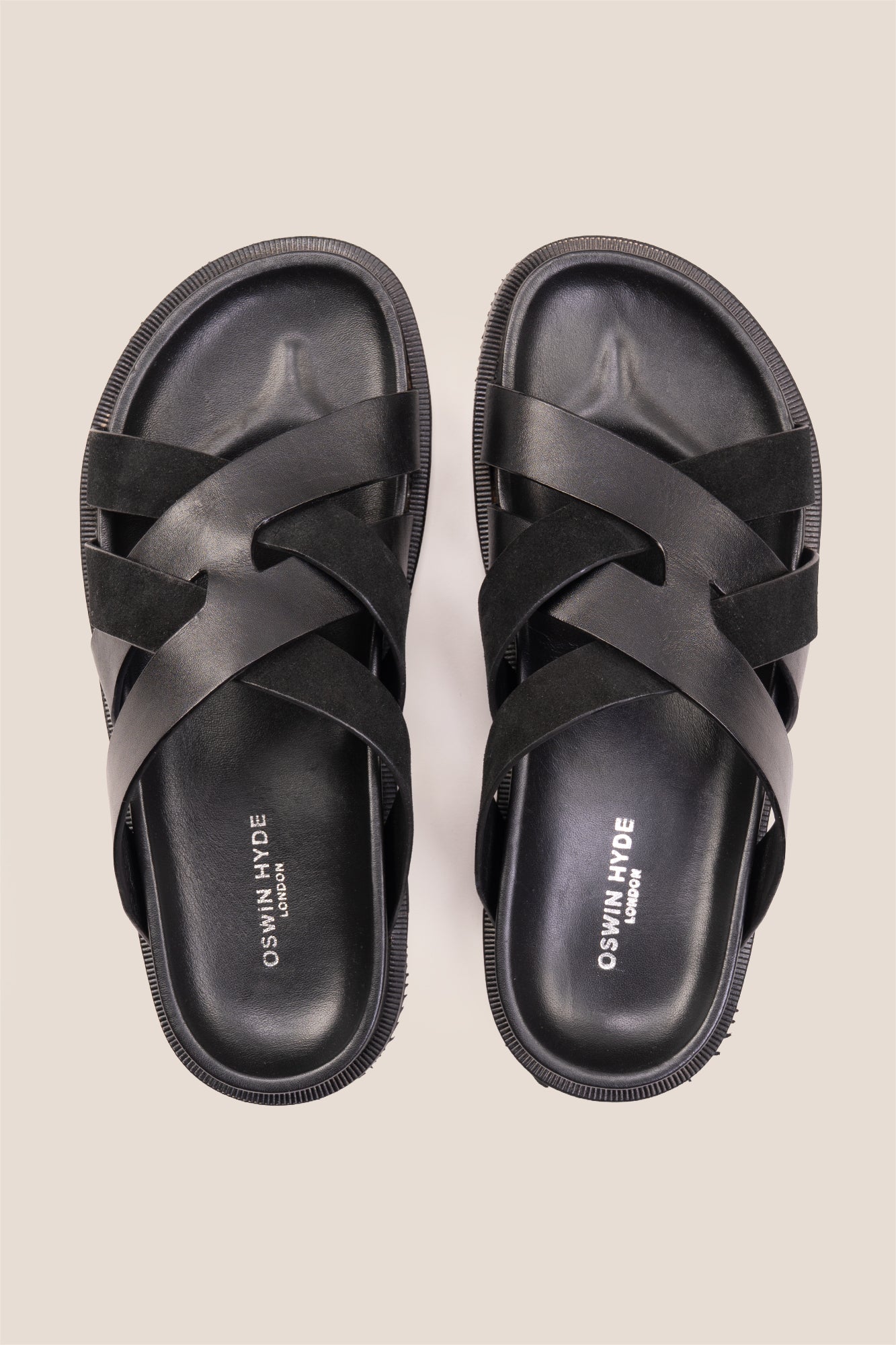 Men’s Rowan Black slide sandals featuring a minimalist black leather X-strap design and a sleek matte finish.