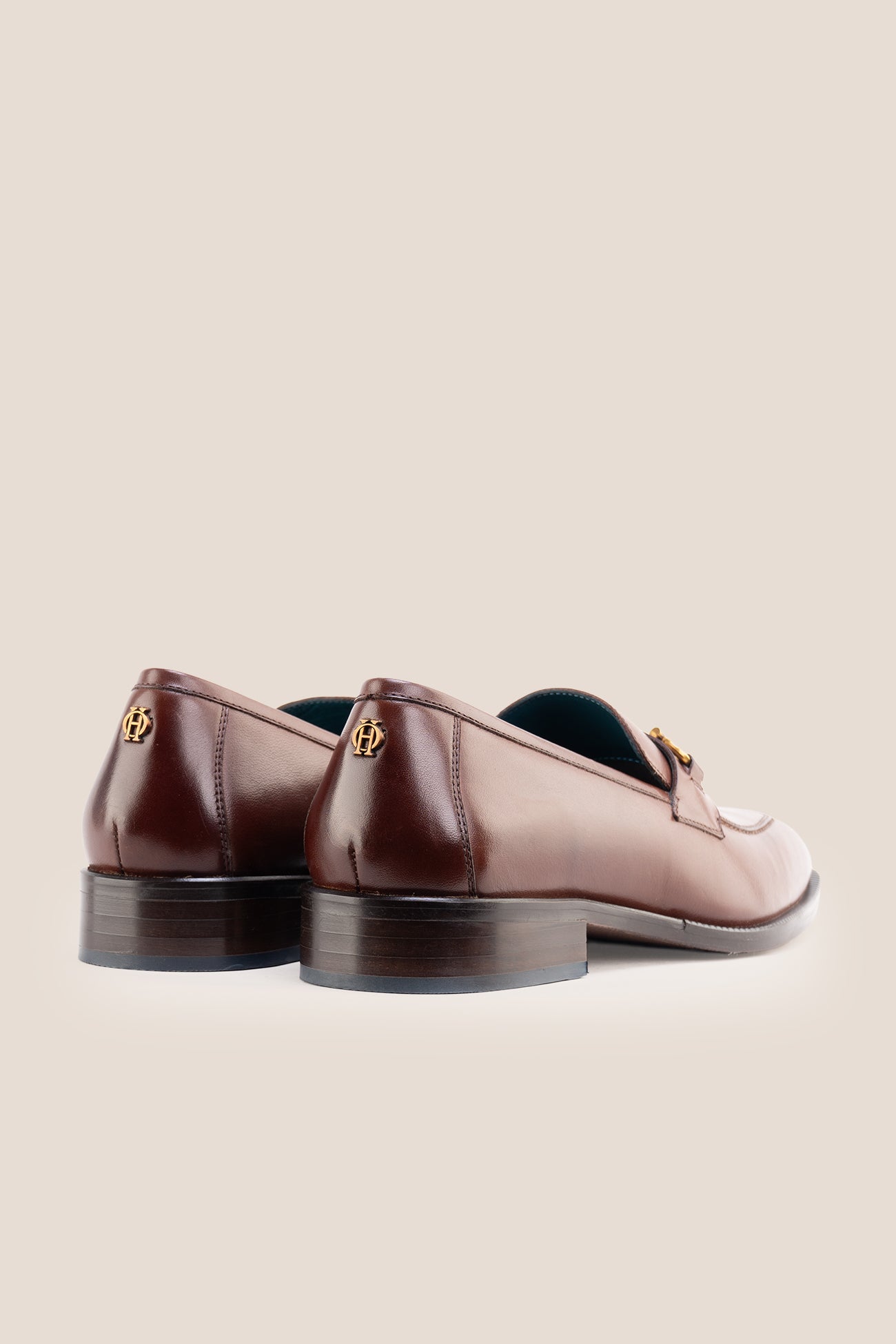 The men's smart brown loafers feature an iconic gold horsebit detail and rich dark brown full-grain leather, perfect for dressing up suits, business settings, and elevating casual wear.