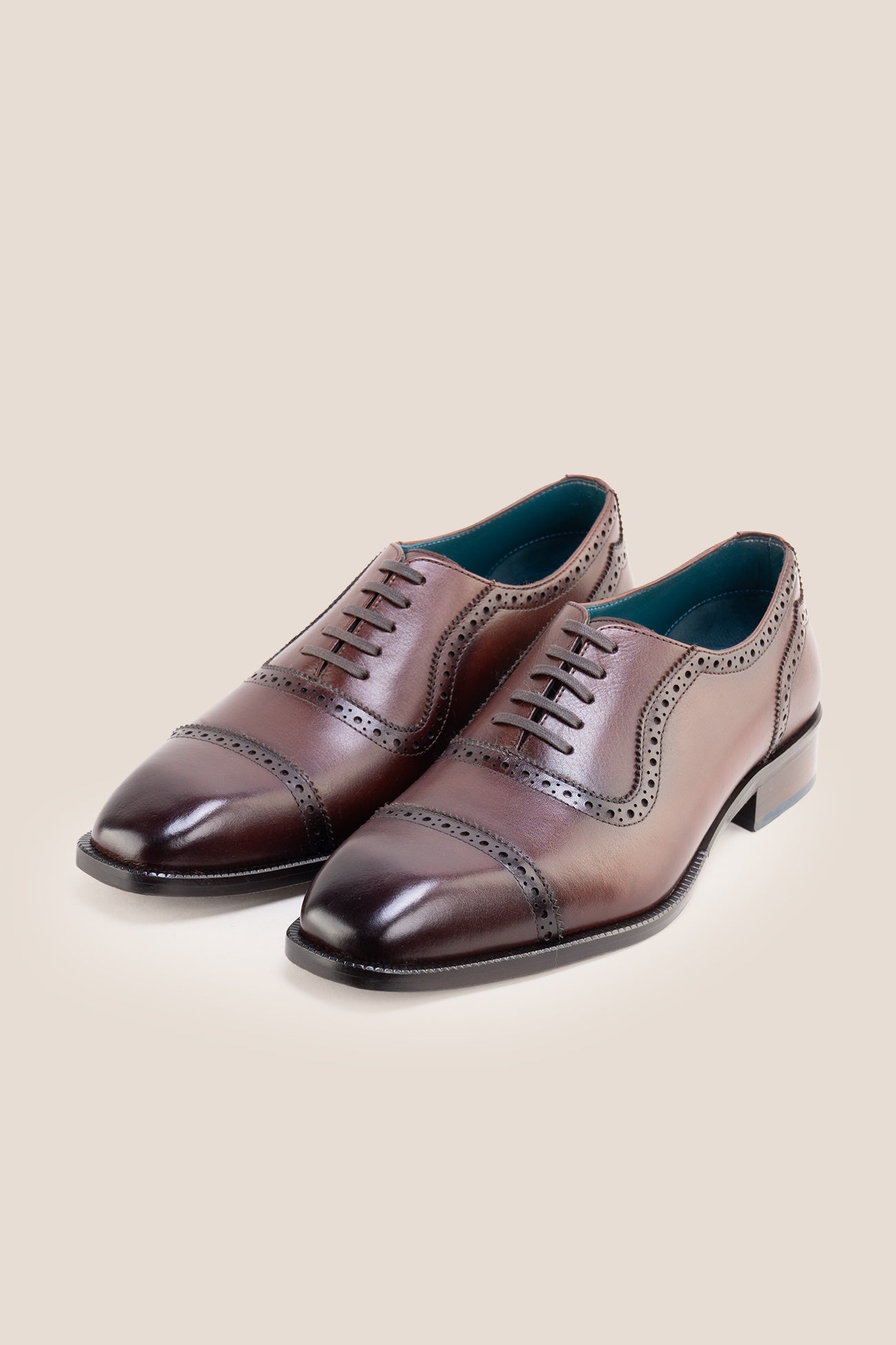 The men's smart brown oxford shoes showcase a refined cap-toe design with delicate brogue detailing and rich full-grain leather, perfect for weddings, formal events, and boardroom attire.