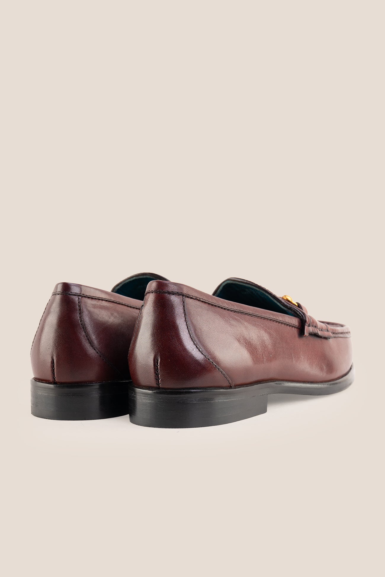 Pair of Oswin Hyde Samuel Bordo burgundy leather horsebit loafers with gold buckle detail and teal lining.