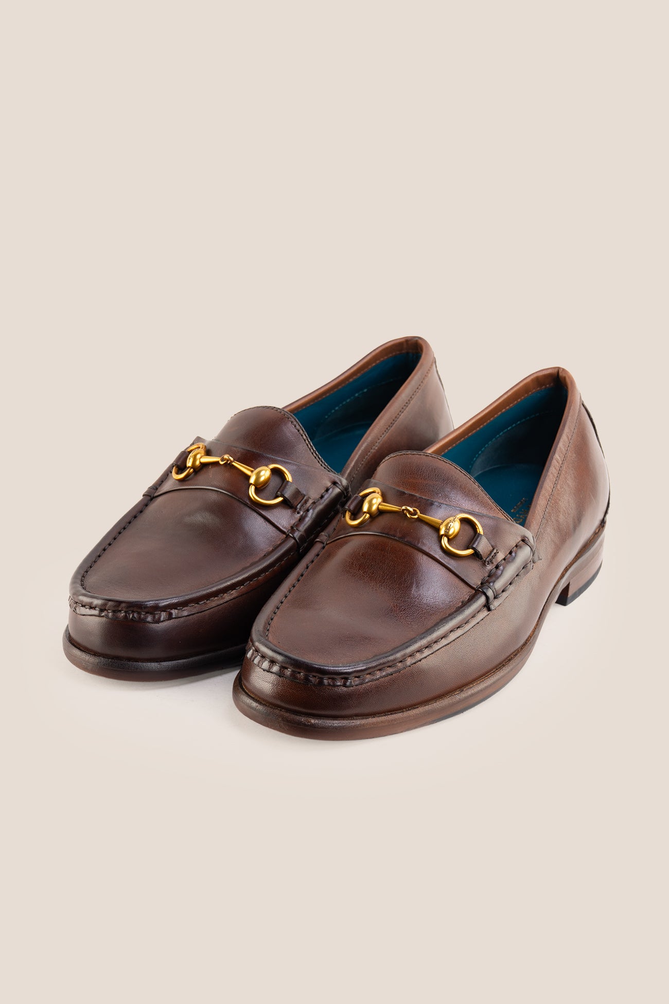 Pair of Oswin Hyde Samuel dark brown leather horsebit loafers with gold buckle detail and teal lining.