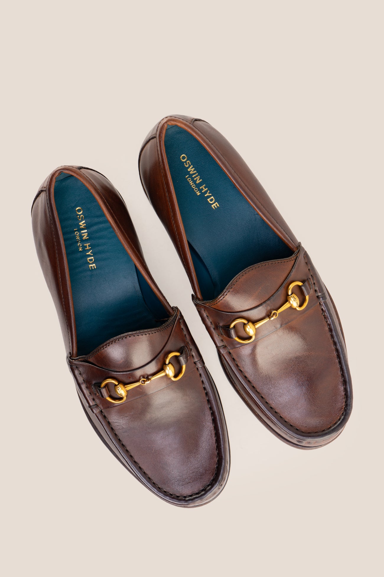 Pair of Oswin Hyde Samuel dark brown leather horsebit loafers with gold buckle detail and teal lining.