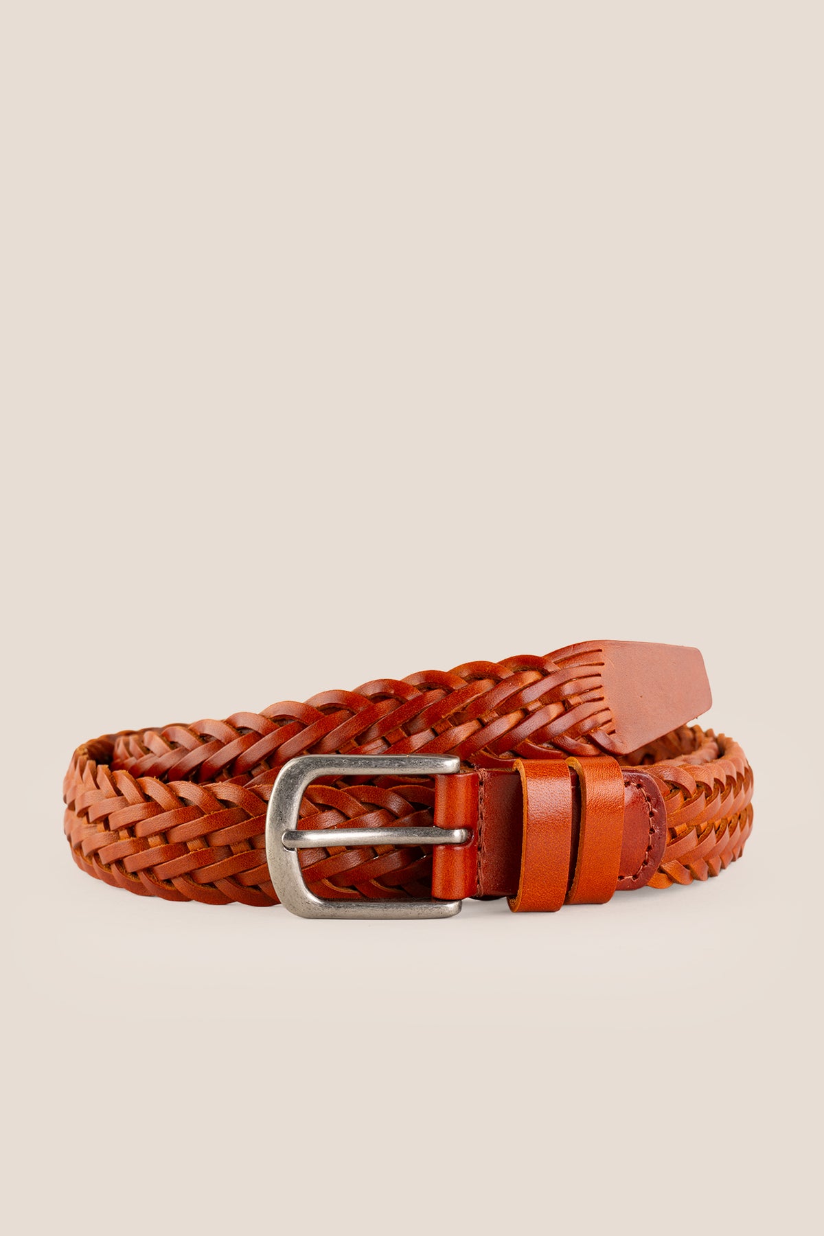 Side profile view of the Milo tan braided leather belt rolled neatly on a neutral background.