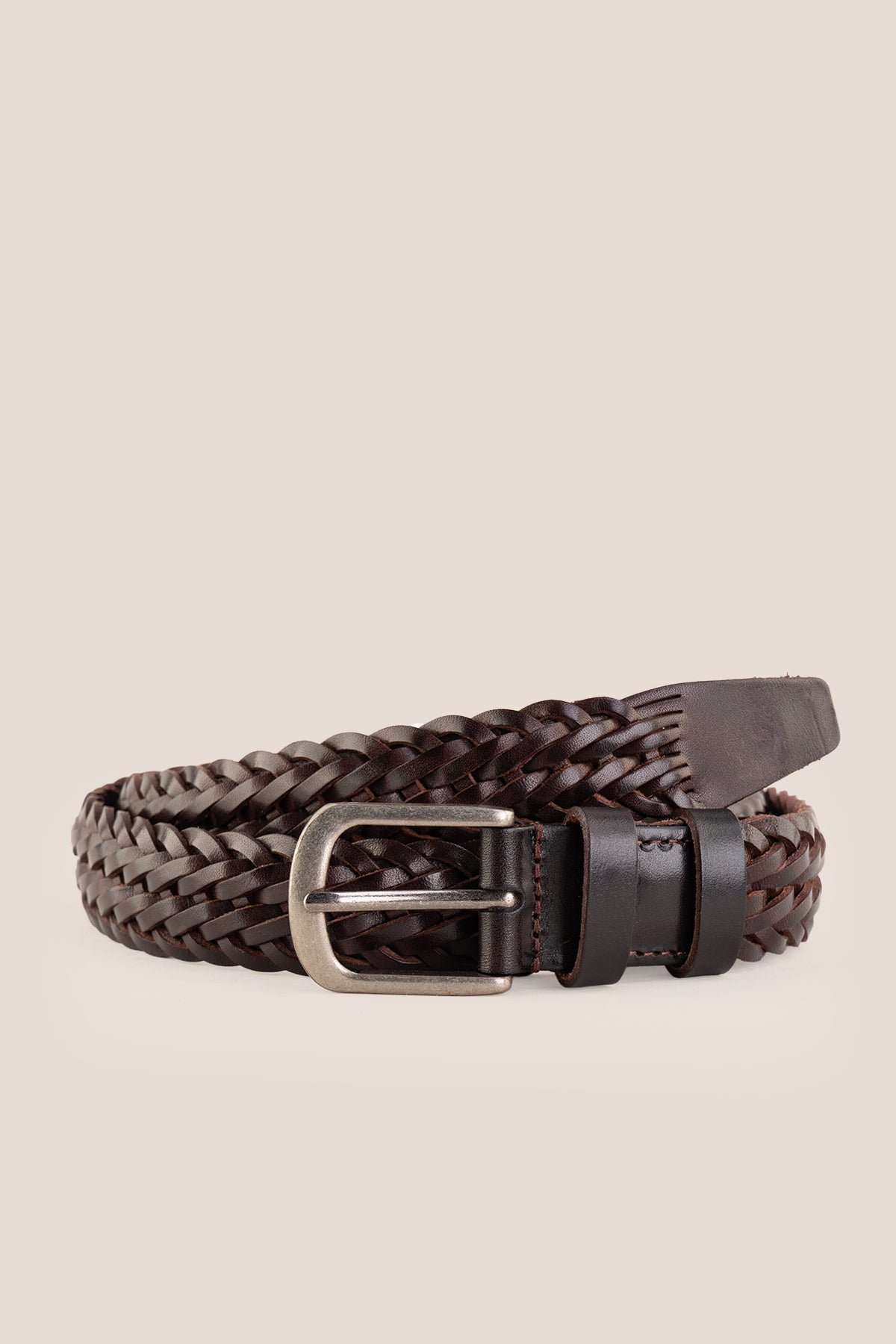 Milo brown braided leather belt rolled neatly showing front silver buckle on a neutral background.