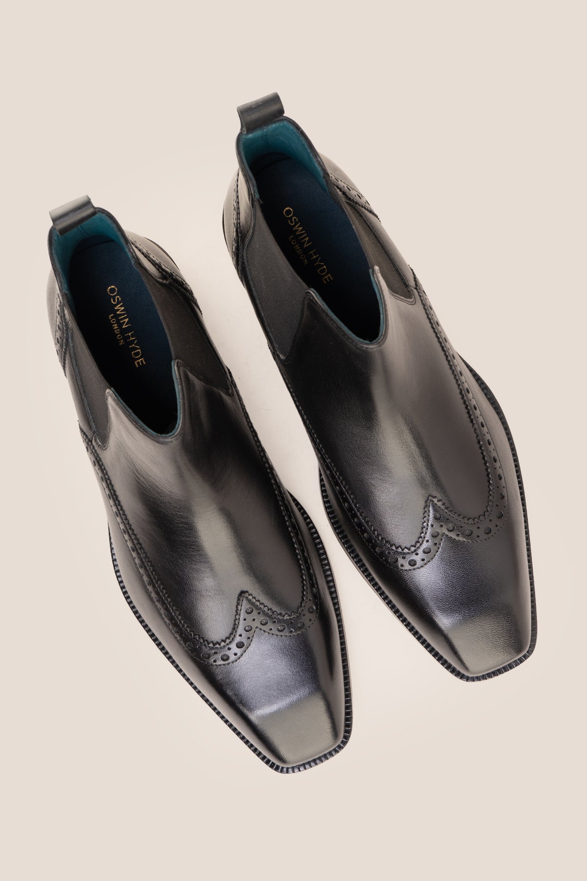 Men's Edgar Black leather brogue Chelsea boots by Oswin Hyde featuring wingtip detailing and elastic side gussets.