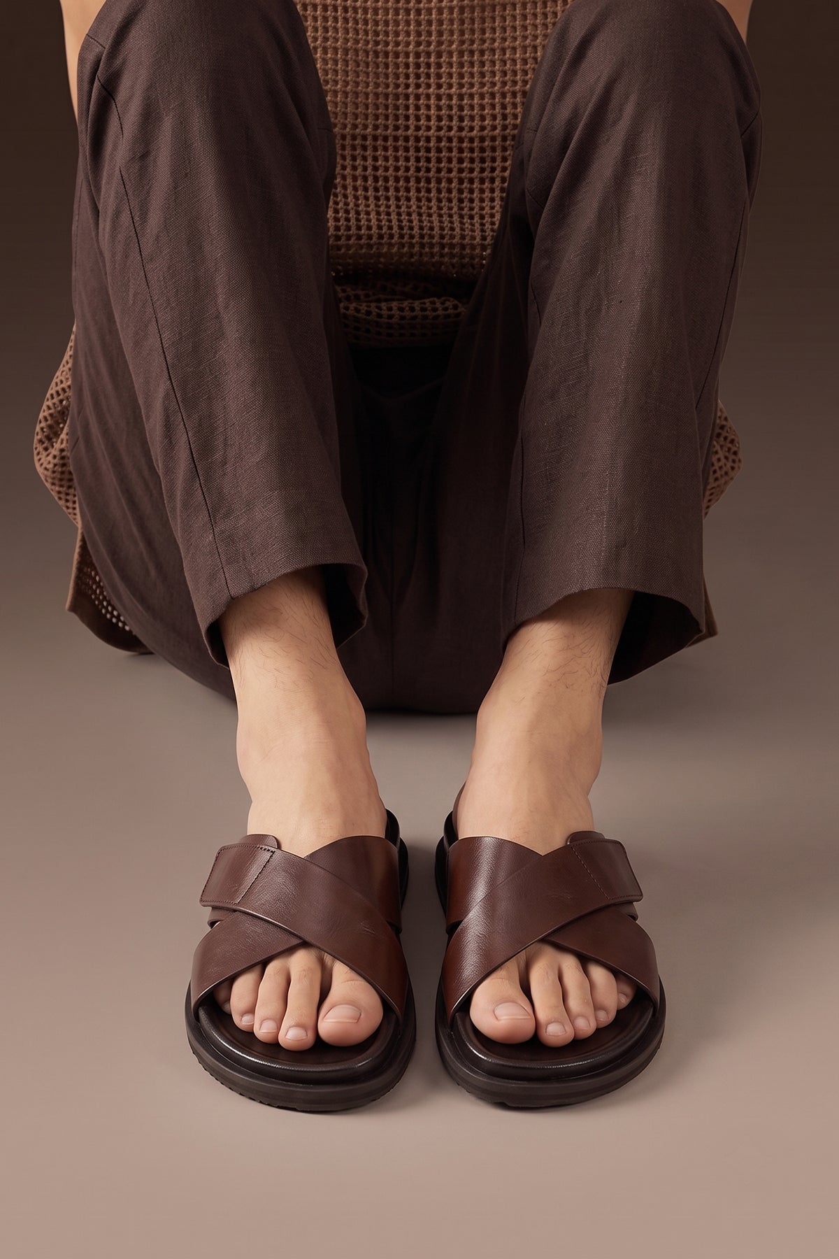 Model wearing Dylan Brown leather men’s sandals with cross strap and velcro closure, perfect for casual wear, holidays, or summer outings.