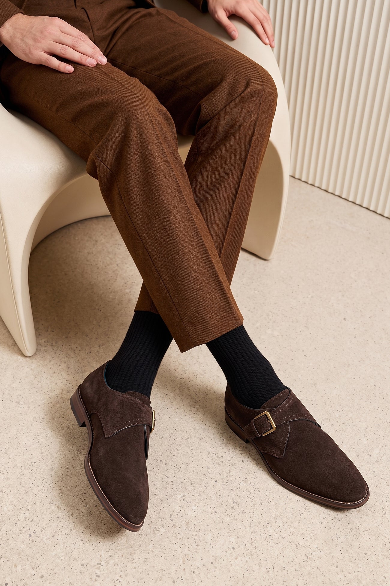 Man wearing Premium men's brown suede single monk strap shoes by Oswin Hyde London, featuring a plain toe, adjustable silver buckle, contrast sole stitching, and a cushioned teal interior.