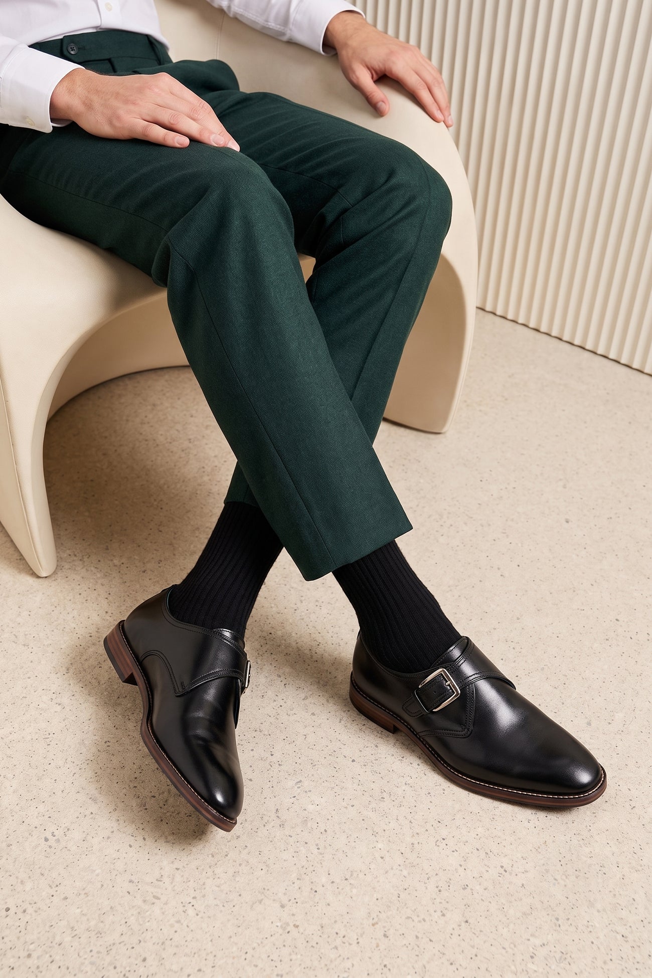 Man wearing Premium men's black leather single monk strap dress shoes by Oswin Hyde London featuring a plain toe, adjustable silver buckle, contrast sole stitching, and a cushioned teal interior.