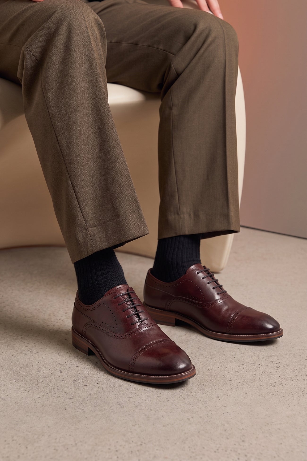 Man wearing Premium men's Bordo leather oxford shoes by Oswin Hyde London, featuring a cap toe with decorative perforations, closed lacing, contrast welt stitching, and a cushioned teal interior.