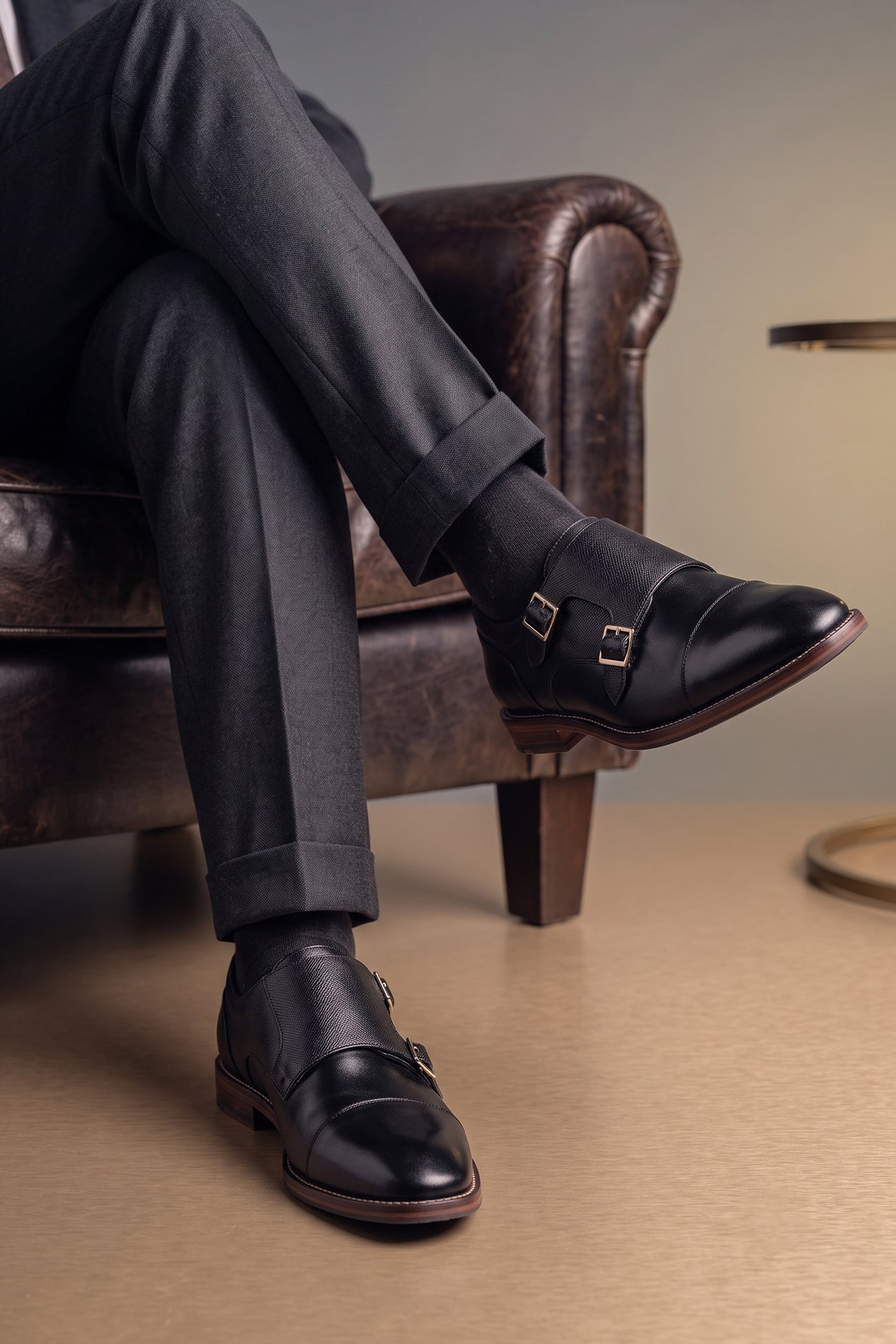 Model wearing Kayden Black leather monk strap shoes by OSWIN HYDE for men. Toe cap designed with saffiano print, cushioned insole and padded topline.