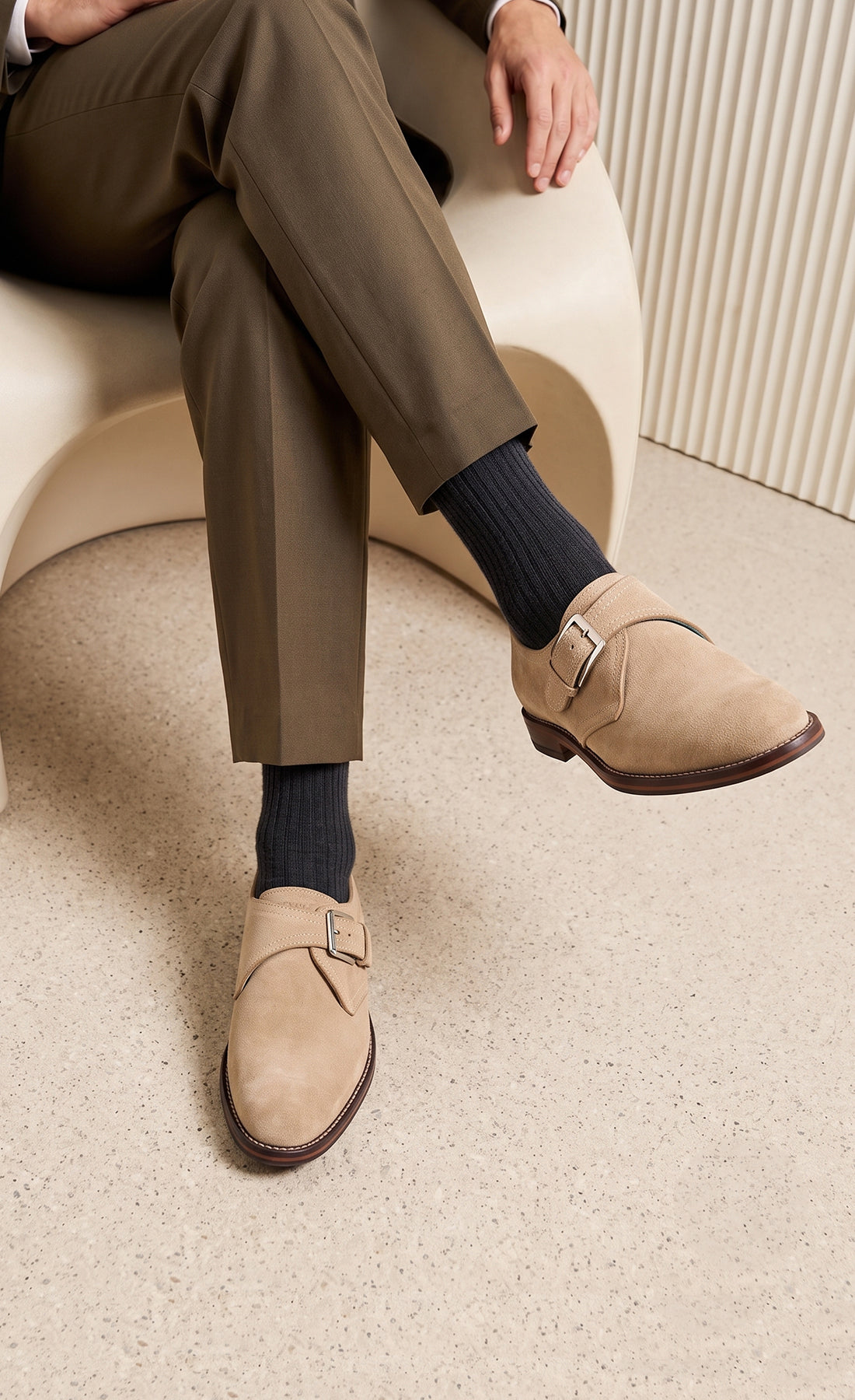 Man wearing Premium men's sand suede single monk strap shoes by Oswin Hyde London, featuring a plain toe, adjustable silver buckle, contrast sole stitching, and a cushioned teal interior.