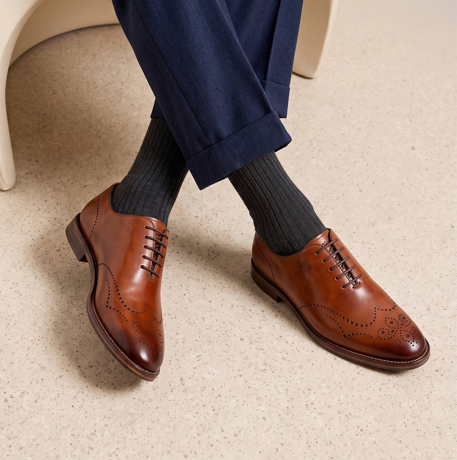 Man wearing Oswin Hyde London premium Tan leather wingtip brogues with a toe medallion pattern, contrast welt stitching, and a cushioned teal interior.