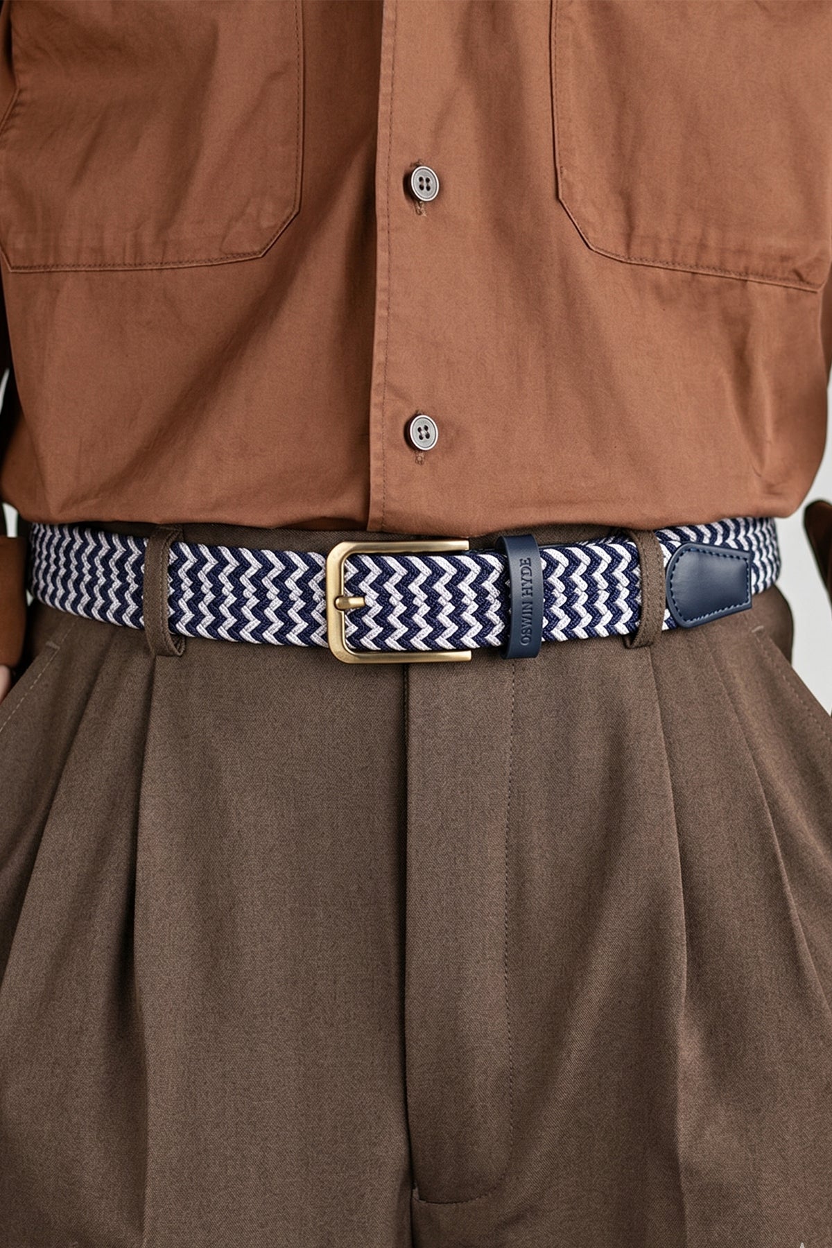 Man wearing the Clyde White Blue Belt with a rust shirt and olive trousers