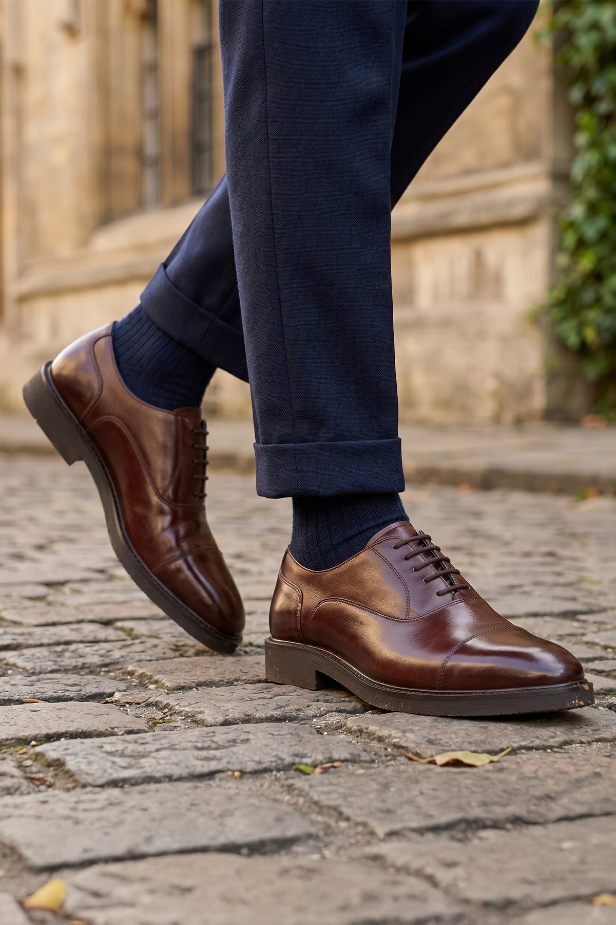 Model wearing Oswin Hyde Flint Brown, classic brown leather Oxford shoes with lace-up design, premium craftsmanship, breathable lining, and durable sole
