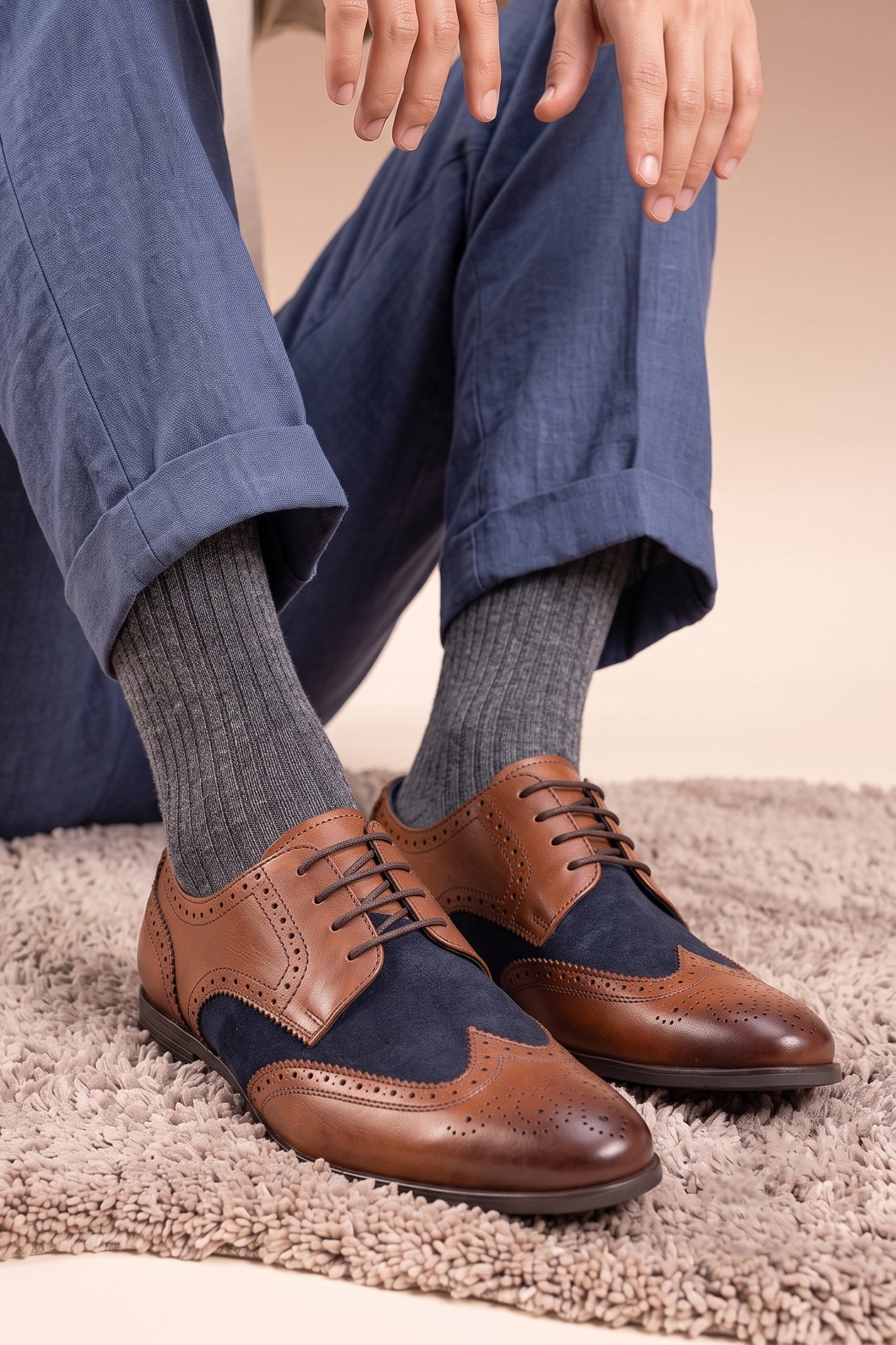 Model wearing Miller Tan Navy Suede men’s leather and  navy suede brogue shoes with wingtip detailing.