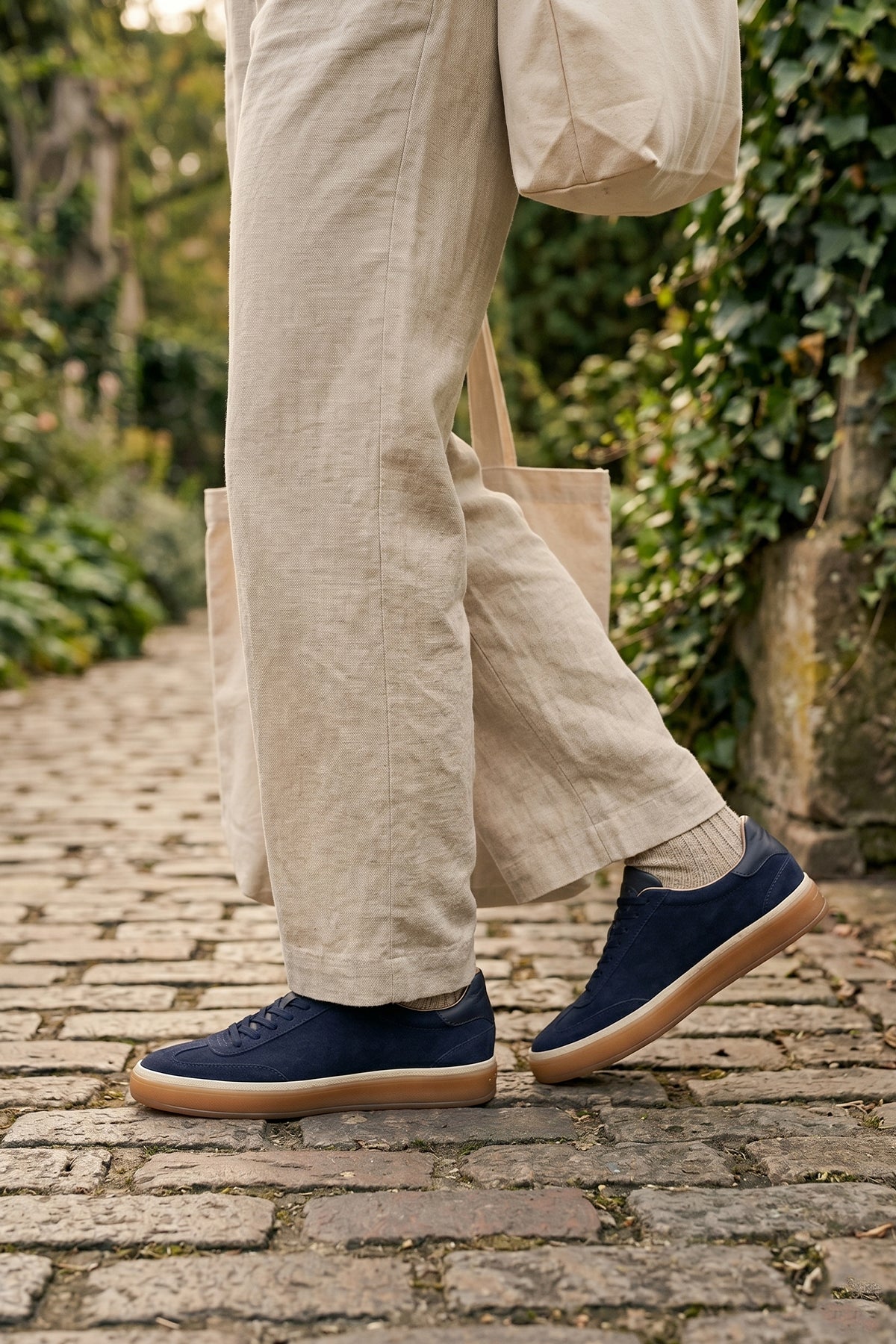 Model wearing Smith navy suede men's sneakers with a sleek seven-eyelet design, crafted from premium suede for modern style, comfort, and durability
