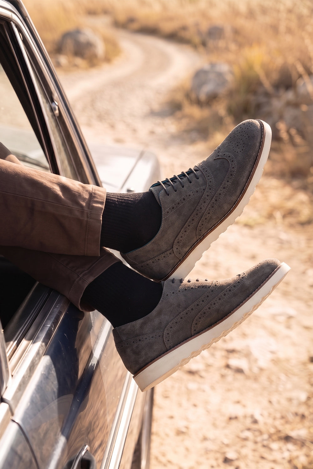 Men’s Tyler grey suede Oxford brogue trainer shoes with perforated detailing, leather lining, and a sleek white sole for elegant everyday wear.