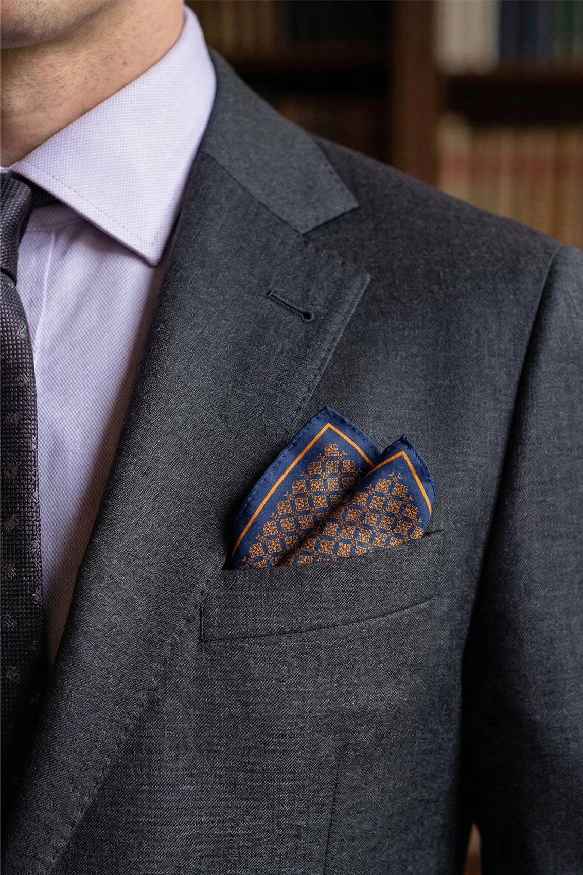 Men’s orange silk handkerchief with an intricate geometric pattern, crafted for weddings, formal occasions, or stylish smart dressing.