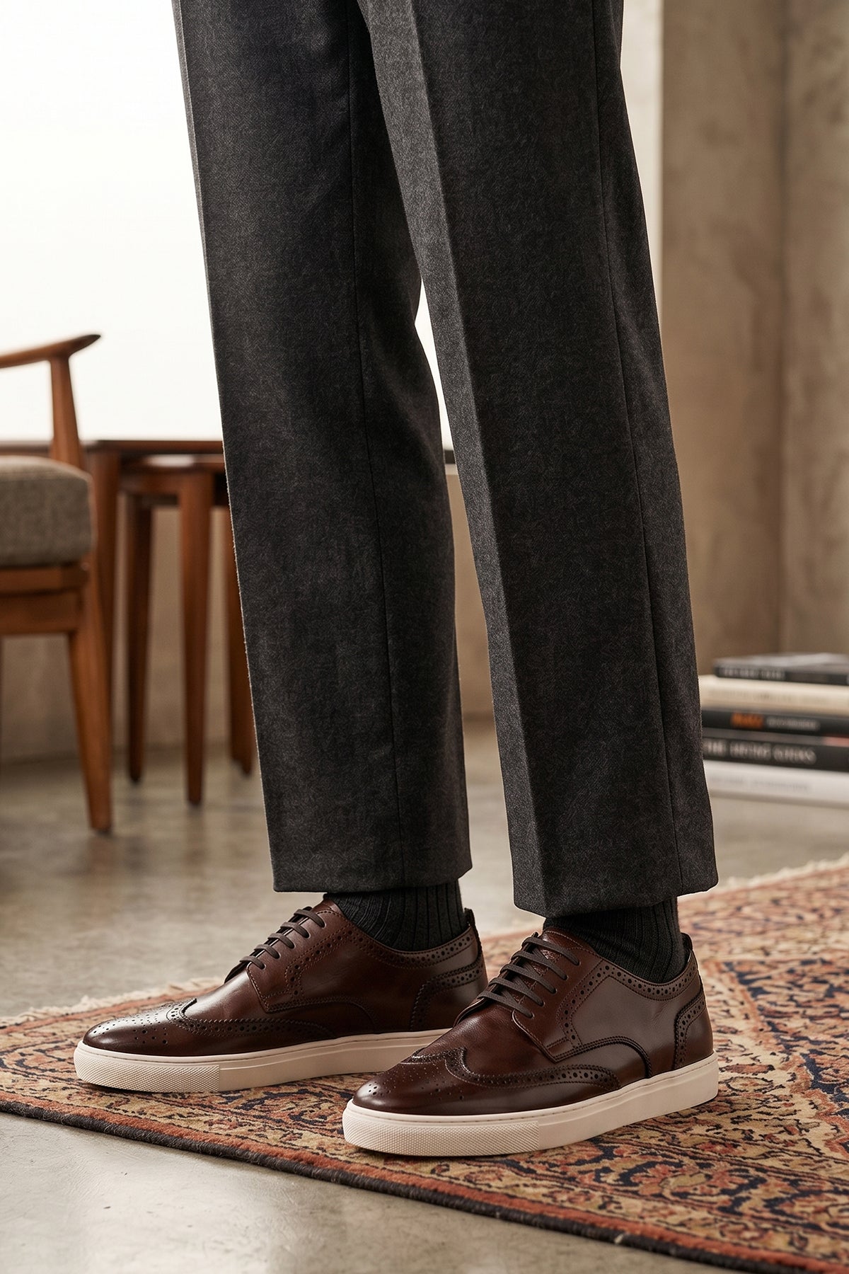 Model wearing Stan Brown wingtip brogue trainer shoes for men, crafted from premium leather with classic wingtip detailing and modern trainer sole.