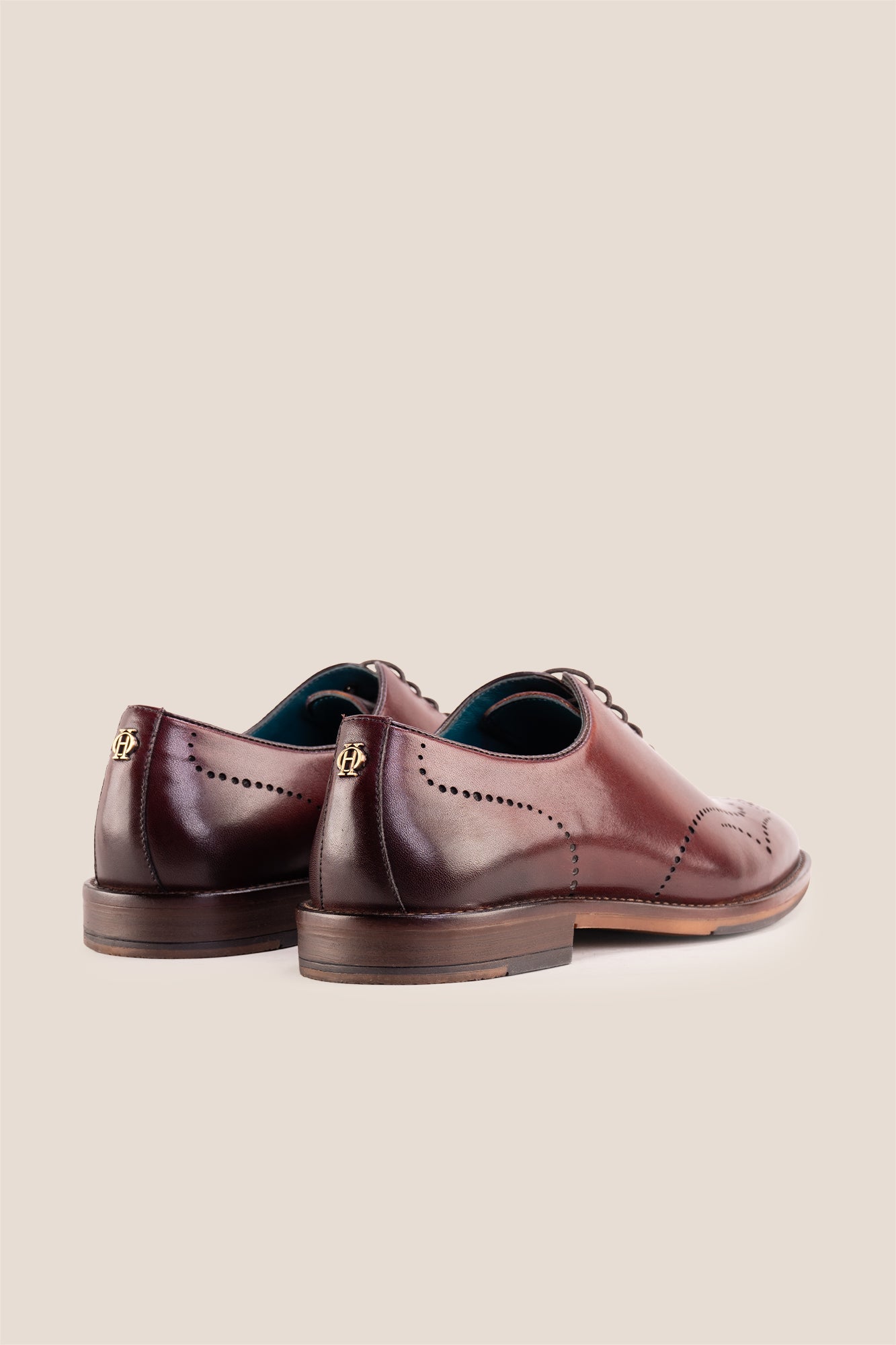 Oswin Hyde London premium bordo leather wingtip brogues with a toe medallion pattern, contrast welt stitching, and a cushioned teal interior.