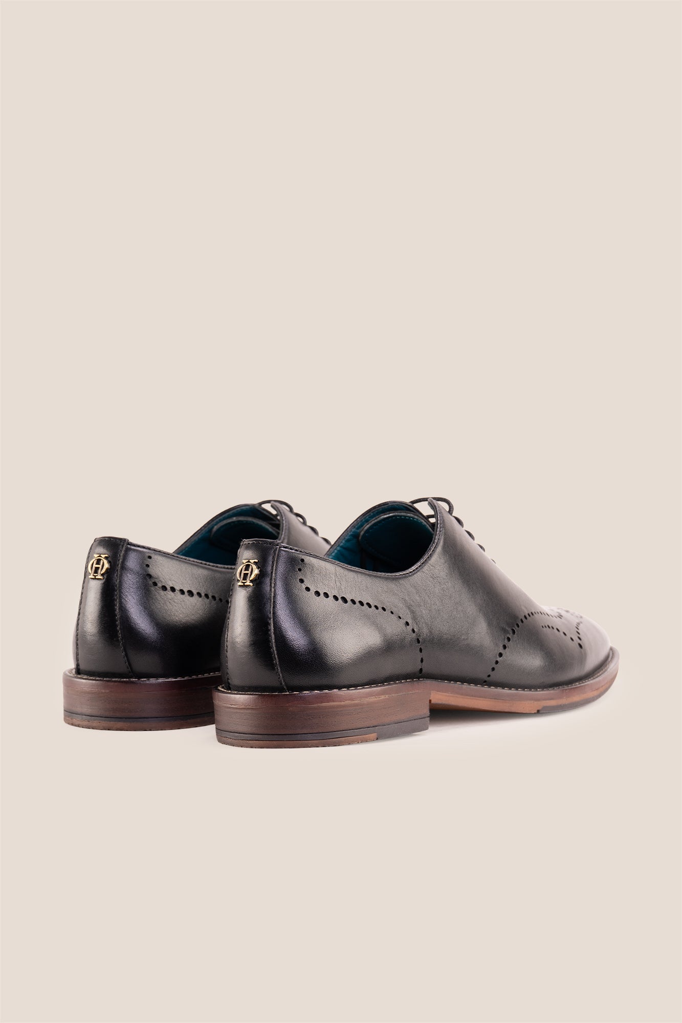 Oswin Hyde London premium black leather wingtip brogues with a toe medallion pattern, contrast welt stitching, and a cushioned teal interior.