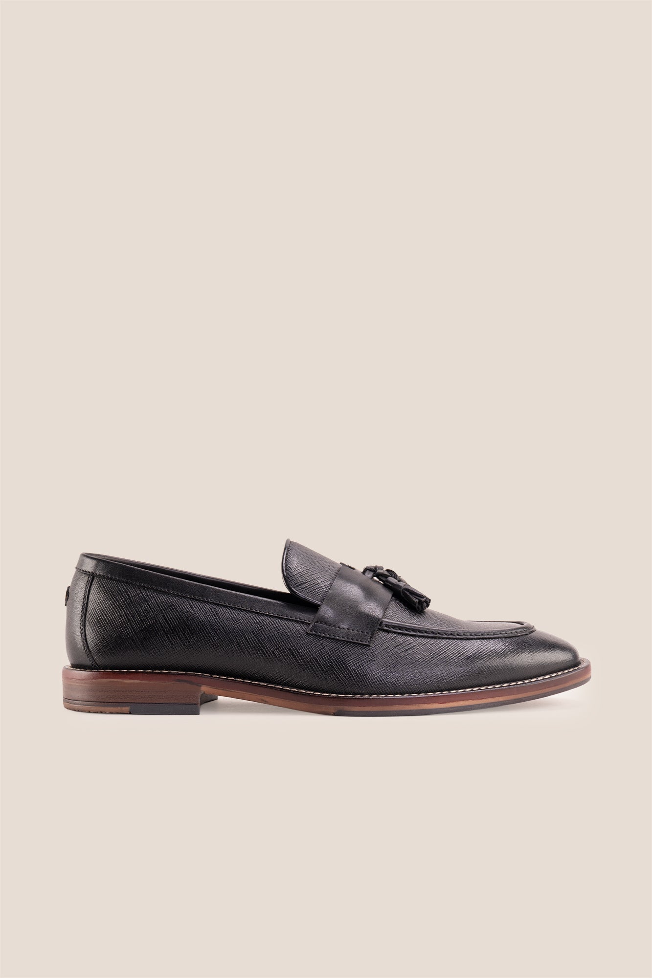 Premium black leather tassel loafers for men featuring a textured finish, burnished moc-toe details, decorative leather tassels, and a cushioned teal interior.