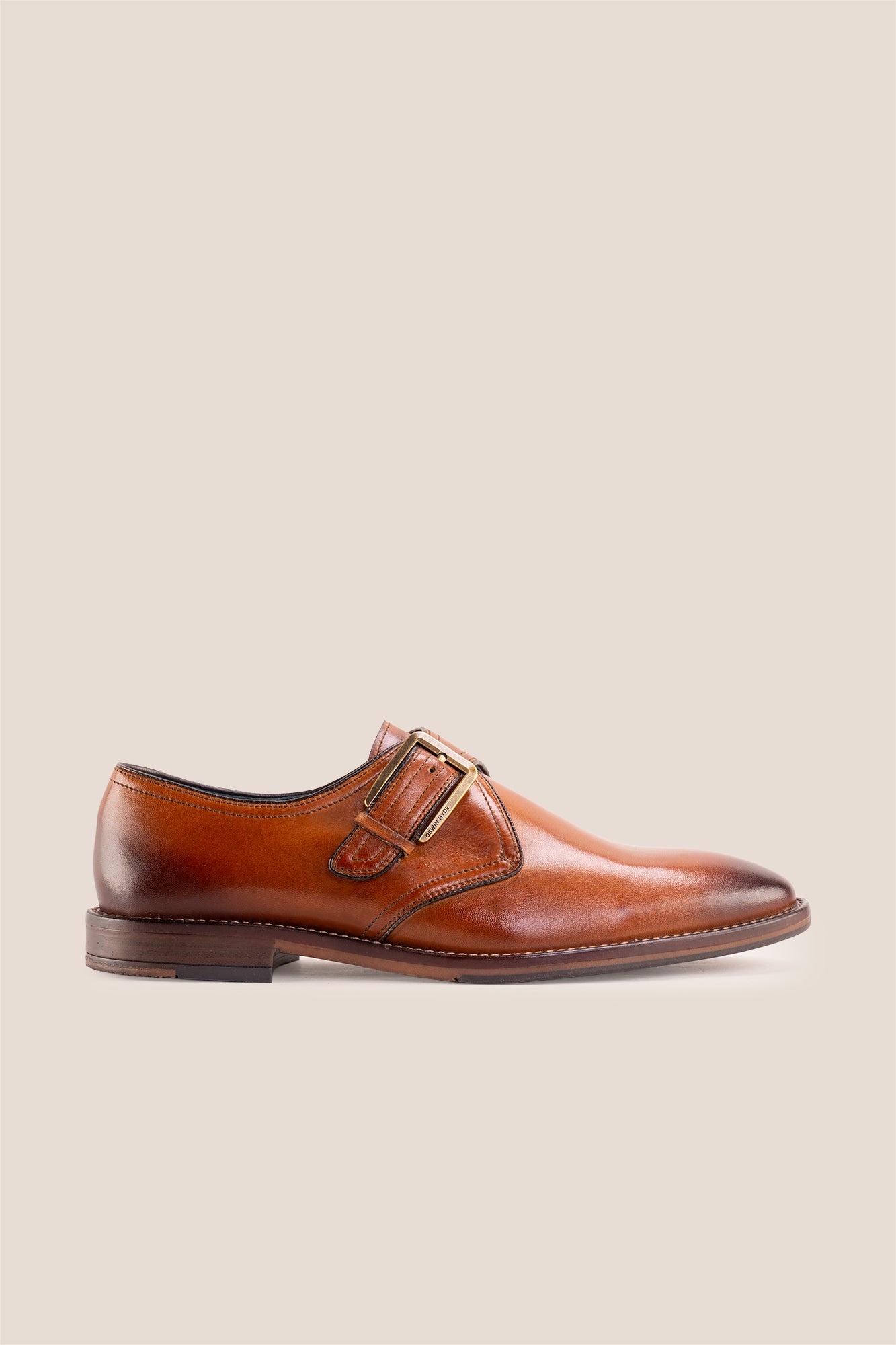 Premium men's tan leather single monk strap dress shoes by Oswin Hyde London featuring a plain toe, adjustable golden buckle, contrast sole stitching, and a cushioned teal interior.