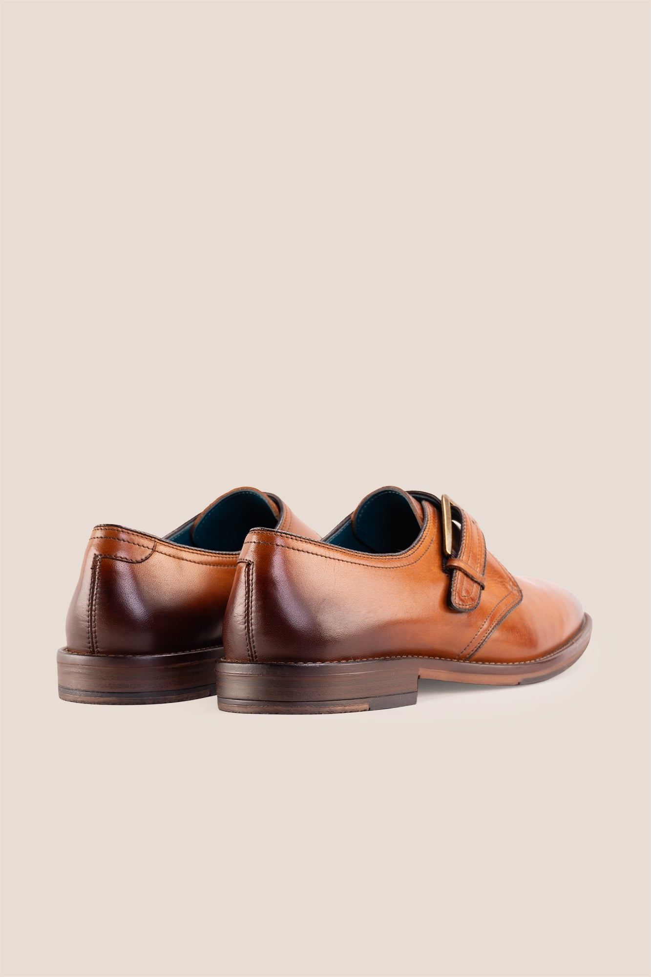 Premium men's tan leather single monk strap dress shoes by Oswin Hyde London featuring a plain toe, adjustable golden buckle, contrast sole stitching, and a cushioned teal interior.