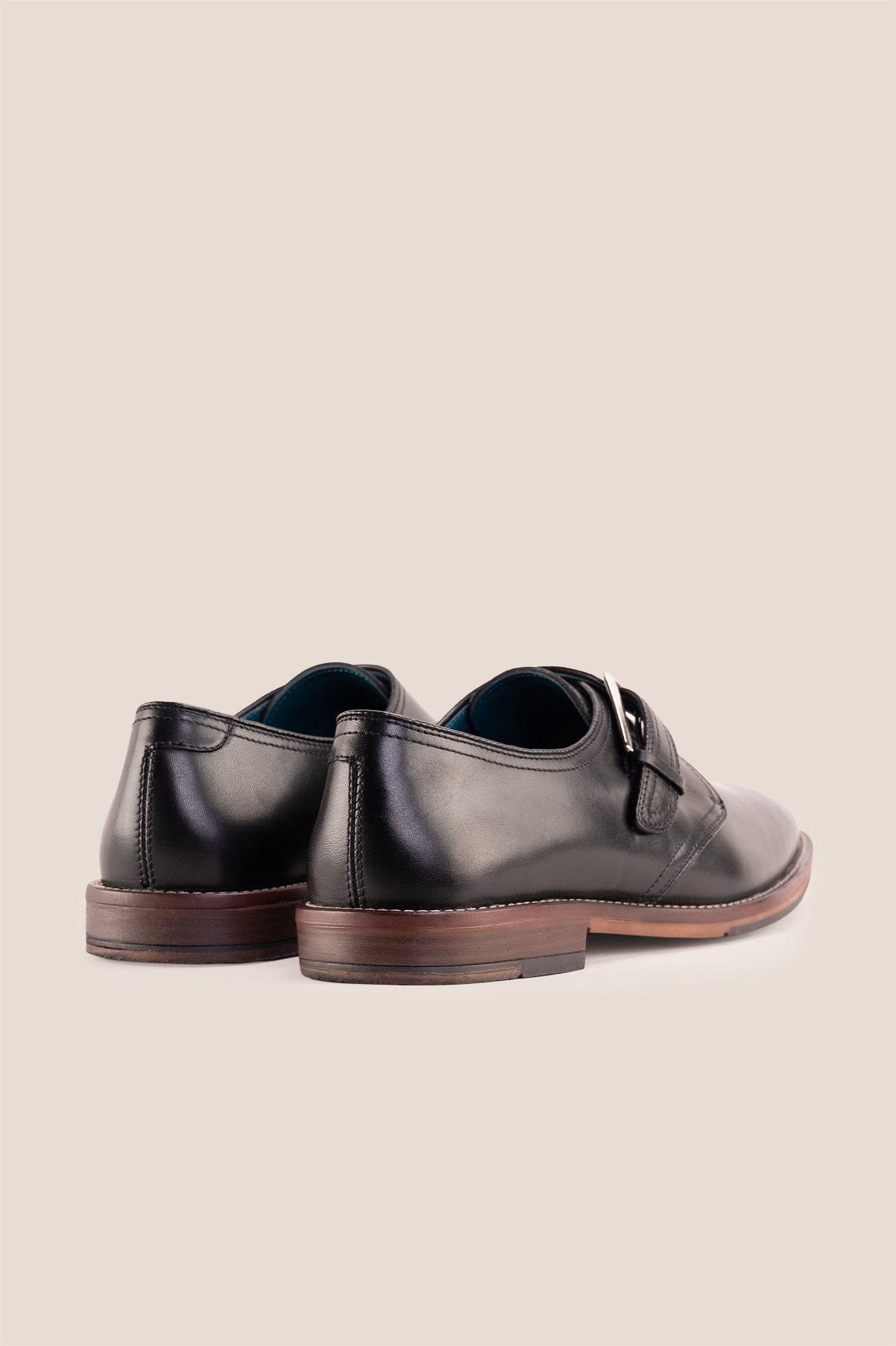 Premium men's black leather single monk strap dress shoes by Oswin Hyde London featuring a plain toe, adjustable silver buckle, contrast sole stitching, and a cushioned teal interior.