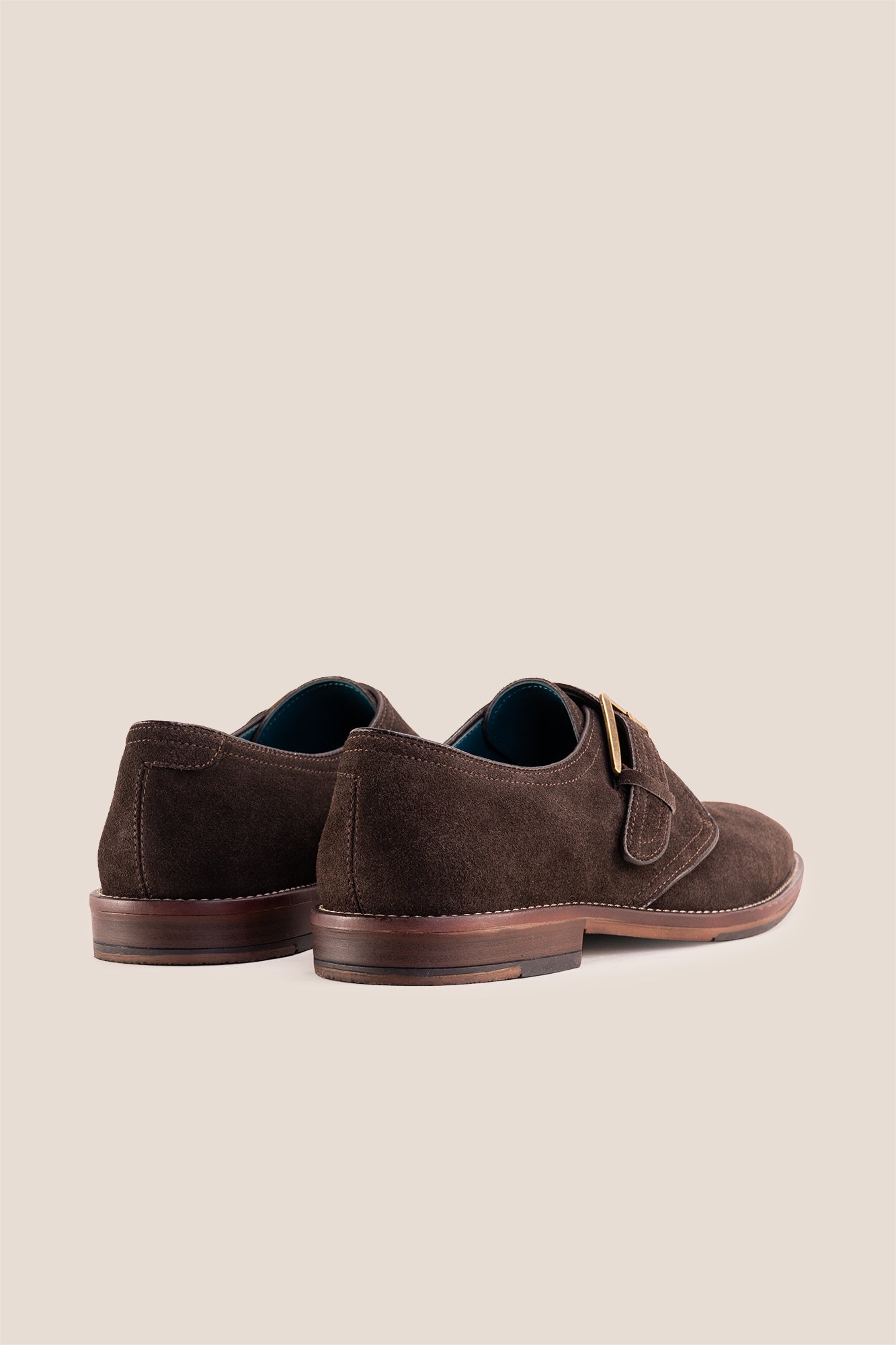 Premium men's brown suede single monk strap shoes by Oswin Hyde London, featuring a plain toe, adjustable silver buckle, contrast sole stitching, and a cushioned teal interior.