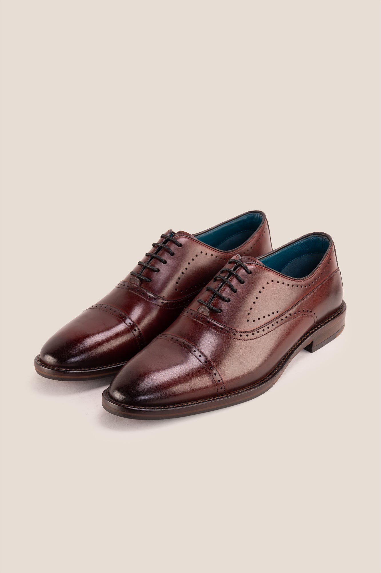 Premium men's Bordo leather oxford shoes by Oswin Hyde London, featuring a cap toe with decorative perforations, closed lacing, contrast welt stitching, and a cushioned teal interior.