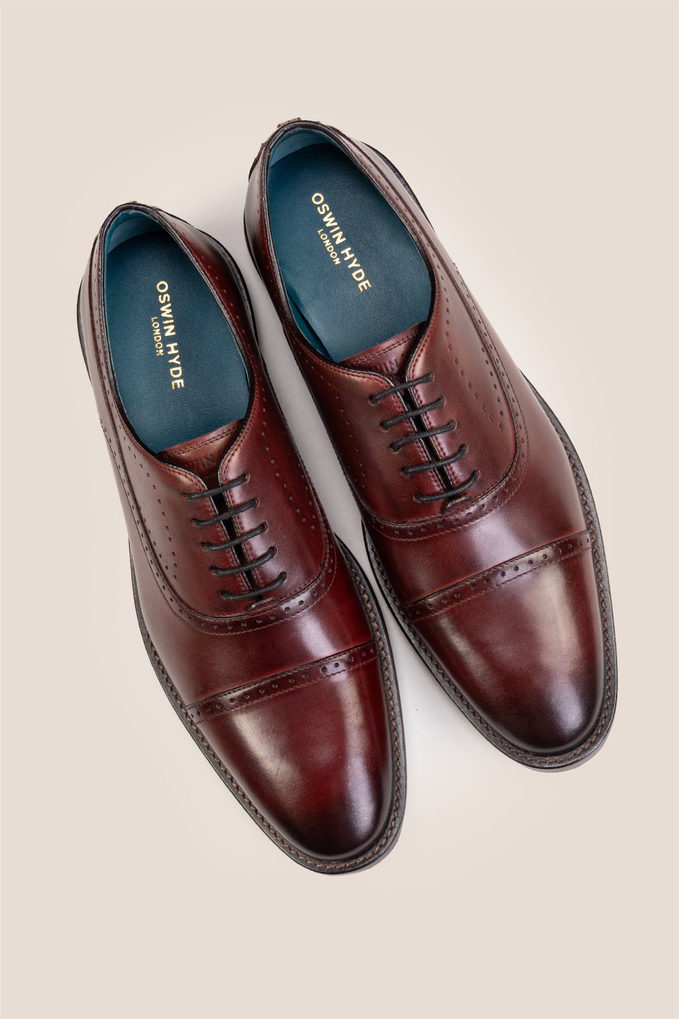 Premium men's Bordo leather oxford shoes by Oswin Hyde London, featuring a cap toe with decorative perforations, closed lacing, contrast welt stitching, and a cushioned teal interior.