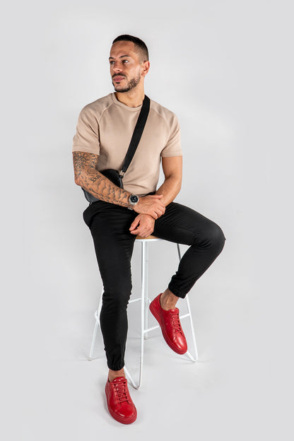 model wearing Men's red leather trainers with red sole