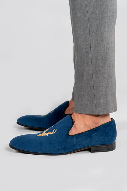 man wearing Men's navy velvet loafers with stag embroidery 