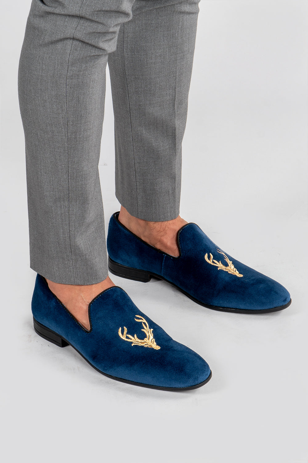 man wearing Men's navy velvet loafers with stag embroidery 
